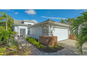 Charming single Gathering home featuring manicured landscaping and an attached two-car garage at 7742 Whitebridge Gln, University Park, FL 34201