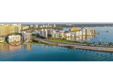 Stunning aerial view showcasing the pink condo building's waterfront location and the city skyline at 37 Sunset Dr # 12, Sarasota, FL 34236