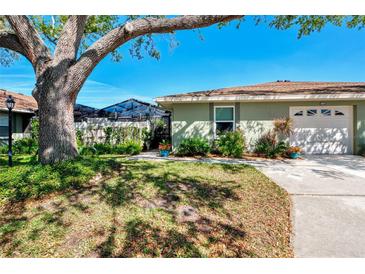 Charming one-story home with a well-manicured lawn, mature landscaping, and a screened pool enclosure at 4091 Center Pointe Pl # 40A, Sarasota, FL 34233