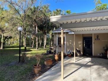 Charming single-story home features a covered carport, mature landscaping, and well-maintained front yard at 5013 Village Gardens Dr # 34, Sarasota, FL 34234