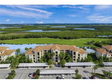 Stunning aerial view of condo complex overlooking a lake and golf course, with covered parking at 7015 River Hammock Dr # 204, Bradenton, FL 34212