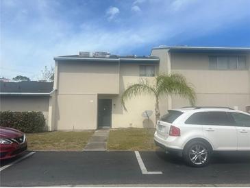 Two-story tan townhouse with a palm tree in the front yard at 965 Whitman Dr, Sarasota, FL 34243