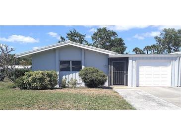 Charming single-story home featuring a well-maintained lawn and attached garage at 3140 Village Green Dr # 1119, Sarasota, FL 34239
