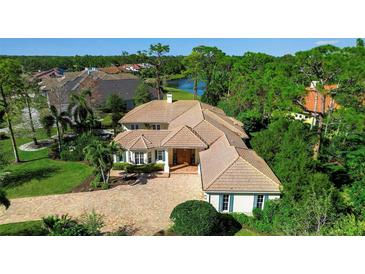 Stunning home with a tile roof, paver driveway, lush landscaping, and serene water views at 402 Walls Way, Osprey, FL 34229