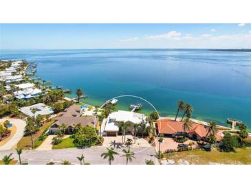 Stunning waterfront home with lush landscaping, private dock, and sparkling blue waters at 606 Crestwood Ln, Holmes Beach, FL 34217