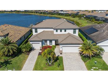 Beautiful two-story home with tile roof, attached two-car garage, mature landscaping, and water view at 6410 Rosehill Farm Run, Bradenton, FL 34211