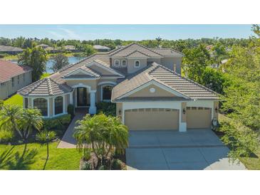 Elegant home features a tile roof, three-car garage and a well manicured lawn at 6915 Honeysuckle Trl, Lakewood Ranch, FL 34202