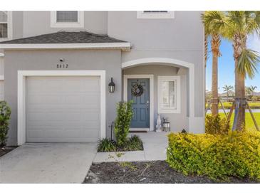 Charming home exterior with a blue front door, attached garage, and well-maintained landscaping at 8612 Lunar Skye St, Sarasota, FL 34241