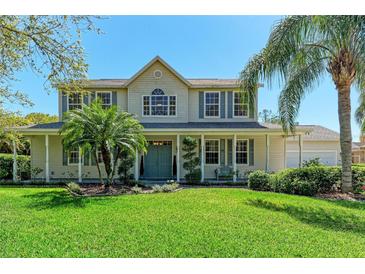 Inviting two-story home with a manicured lawn, charming front porch, and lush landscaping at 14530 17Th E Ave, Bradenton, FL 34212