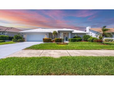 Charming single-story home featuring a lush green lawn and meticulously maintained landscaping at 1511 Waterford Dr, Venice, FL 34292