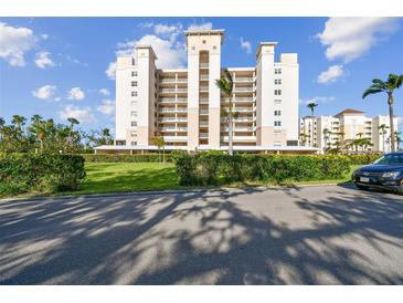 Stunning exterior view of a condo building with a manicured lawn, palm trees, and a car at 2625 Terra Ceia Bay Blvd # 506, Palmetto, FL 34221