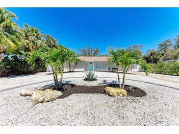 Charming home featuring an artful circular driveway with palm trees and bright, stylish curb appeal at 3304 7Th Street W Ct, Palmetto, FL 34221