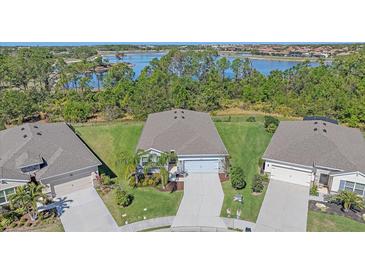 Stunning aerial view of a home with a well-manicured lawn and picturesque lake in the background at 13804 Camden Crest Ter, Lakewood Ranch, FL 34211