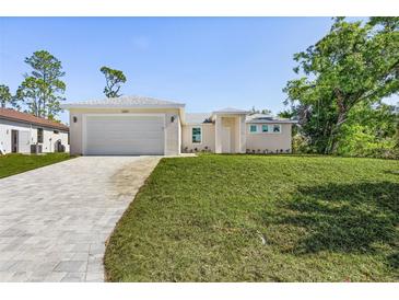 Charming single-story home with a well-manicured lawn and paved driveway leading to a spacious garage at 2364 Carpenter Ln, North Port, FL 34286