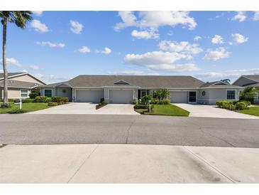 Charming villa with lush landscaping, well-manicured lawns, and a double driveway leading to attached garages at 2908 Fiddlers Bnd, Palmetto, FL 34221