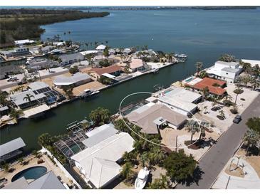 Waterfront home with private dock, screened pool, and lush landscaping on a sunny day at 3708 Plumosa Ter, Bradenton, FL 34210