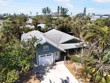 Charming home surrounded by lush landscaping and mature trees offers privacy at 402 71St St, Holmes Beach, FL 34217