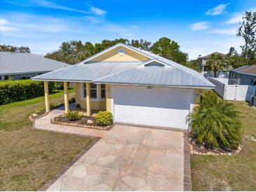 Beautiful one-story home with yellow siding, a gray roof, and an attached two-car garage at 5319 Levi Ln, Sarasota, FL 34233