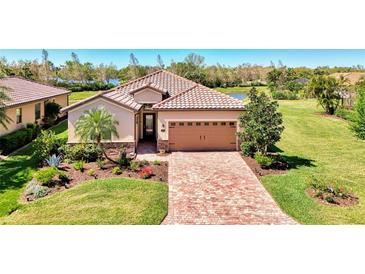Charming single-Gathering home boasting a brick paved drive, manicured lawn and lush landscaping for enhanced curb appeal at 167 Wandering Wetlands Cir, Bradenton, FL 34212