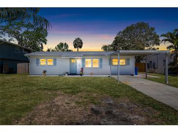 Charming single-story home with a carport and a well-manicured lawn under a beautiful dusk sky at 1827 Nevada Ne Ave, St Petersburg, FL 33703