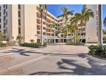 Beautiful multi-story building surrounded by palm trees, lush landscaping, and paver driveways at 1930 Harbourside Dr # 142, Longboat Key, FL 34228