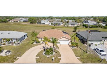 Aerial view of home showcasing a circular driveway, mature landscaping, and well-maintained lawn at 26506 Copiapo Cir, Punta Gorda, FL 33983