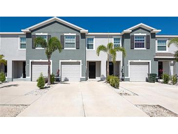 Townhome exterior with garage and a well-maintained front yard, offering an inviting curb appeal at 8657 Milestone Dr, Sarasota, FL 34238