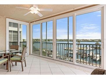 Balcony view with tiled floor, ceiling fan and sliding glass doors overlooking water and boats at 1260 Dolphin Bay Way # 404, Sarasota, FL 34242