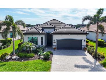 Charming single-story home featuring a beautifully landscaped yard and a gray tile roof at 17604 Hickok Belt Loop, Bradenton, FL 34211