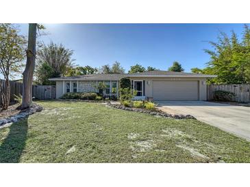 Charming single-story home with stone accents, lush landscaping and a well-manicured front yard at 2818 Indianwood Way, Sarasota, FL 34232