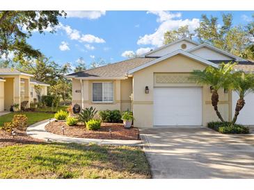 Charming single-story home with a well-manicured lawn, a two-car garage and beautiful landscaping in a warm-toned color palette at 411 28 W St, Palmetto, FL 34221