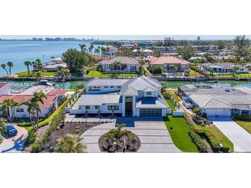 Stunning waterfront home boasting a modern design, circular driveway, and lush landscaping at 560 Schooner Ln, Longboat Key, FL 34228