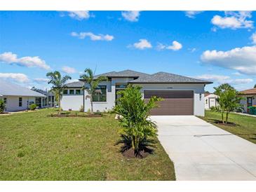 Charming single-Gathering home featuring a well-maintained lawn, two-car garage, and inviting curb appeal at 12396 Bacchus Rd, Port Charlotte, FL 33981