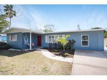Charming single-story home with a blue exterior, red door, and well-maintained front yard at 2001 25Th W Ave, Bradenton, FL 34205
