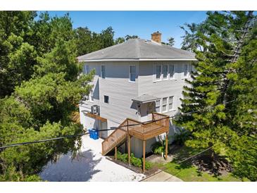 Two-story home with mature trees and multiple wooden decks and stairs at 2003 12Th W Ave, Bradenton, FL 34205