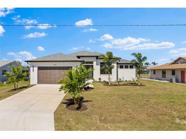 Beautiful single-story home featuring a well-manicured lawn, a two-car garage, and mature palm trees at 2523 Dixon Ter, Port Charlotte, FL 33981