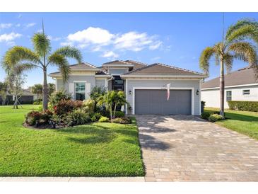 Charming single-story home featuring lush landscaping, brick driveway, and attached two car garage at 25325 Longmeadow Dr, Punta Gorda, FL 33955