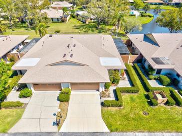 Stunning aerial view of villa with meticulous landscaping, serene water features, and community pool, offering an inviting neighborhood at 4451 Atwood Cay Cir # 7, Sarasota, FL 34233