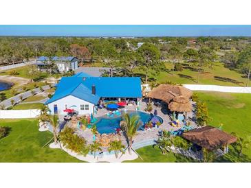 Stunning aerial view showcasing a custom home with a blue roof, luxurious pool area, tiki bar, and beautiful landscaping at 9902 284Th St E E St, Myakka City, FL 34251