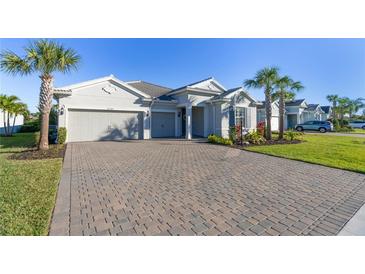 Charming single-story home with a three-car garage, beautiful landscaping, and a brick driveway at 12307 Blue Hill Trl, Bradenton, FL 34211
