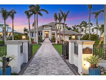 Elegant home showcasing a grand entrance, palm trees, manicured landscaping, and beautiful brick driveway at 1333 Vista Dr, Sarasota, FL 34239