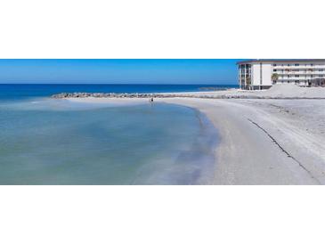 Beautiful view of beach with the condo building in the background on a bright sunny day at 2100 Benjamin Franklin Dr # 104, Sarasota, FL 34236