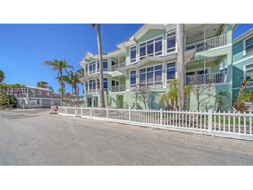 Beautiful three story waterfront home with multiple balconies and a well manicured fenced front yard at 314 Bay S Dr # 5, Bradenton Beach, FL 34217