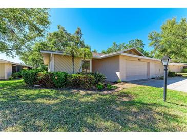 Charming single-story home with a well-maintained lawn, mature trees, and an attached two car garage at 3549 Wilkinson Woods Dr # 38, Sarasota, FL 34231