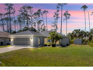 Charming single-story home with a well-maintained lawn and a screened garage, all under a beautiful sunset sky at 3865 N Cranberry Blvd, North Port, FL 34286