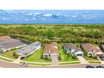 An aerial view showing the property situated on a well-maintained lot, featuring a landscaped yard at 10165 Canaveral Cir, Sarasota, FL 34241