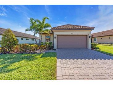 Charming single-story home with a well-manicured lawn, paver driveway, and a two-car garage, perfect for suburban living at 10230 Highland Park Pl, Palmetto, FL 34221