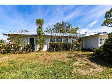 Charming single-story home featuring a well-maintained lawn and mature landscaping at 18422 Burkholder Cir, Port Charlotte, FL 33948