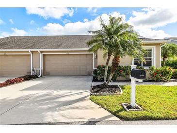 Charming home features a well-manicured lawn, beautiful landscaping, and a two-car garage with a large drive way at 2912 Fiddlers Bnd, Palmetto, FL 34221