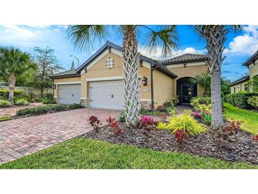 Charming single-story home with a well-manicured lawn, brick driveway, and beautiful landscaping at 6492 Positano Ct, Sarasota, FL 34243